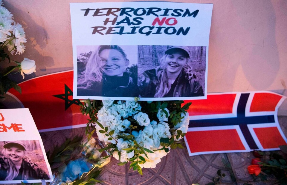 This picture taken on December 21, 2018 shows a combo photo murdered Danish student Louisa Vesterager Jespersen (L) and Nowegian Maren Ueland placed on top of flowers and between the flags of Morocco an Norway as Moroccans pay tribute to the Scandinavian victims. - The bodies of the 24-year-old Danish student 28-year-old Norwegian were found on December 17, after the two friends had pitched their tent at an isolated mountain site two hours' walk from the tourist village of Imlil. (Photo by FADEL SENNA / AFP)