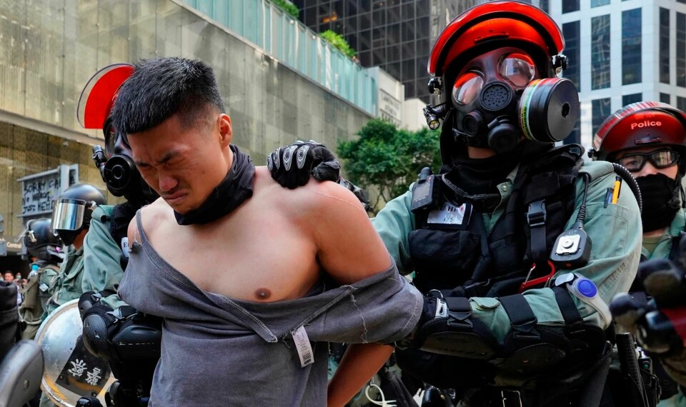 266 demonstranter ble pågrepet i Hongkong mandag. En maskert demonstrant ble skutt av politiet. A protester is detained in Central district of Hong Kong on Monday, Nov. 11, 2019. A Hong Kong protester was shot by police Monday in a dramatic scene caught on video as demonstrators blocked train lines and roads during the morning commute. (AP Photo/Vincent Yu)
