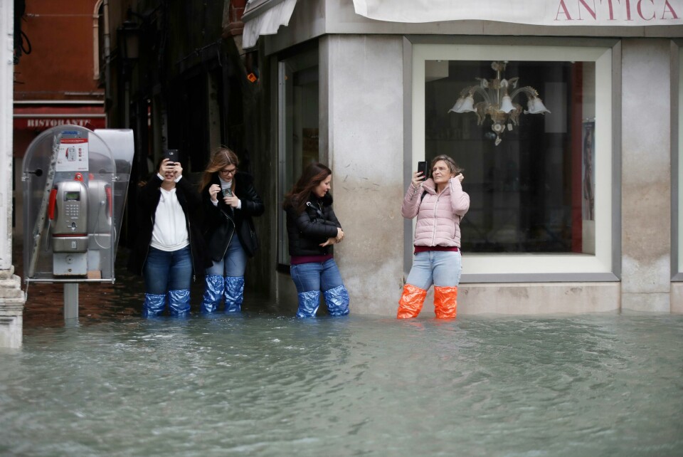 Tourists take pictures of a flooded Venice, Italy, Friday, Nov. 15, 2019. The high-water mark hit 187 centimeters (74 inches) late Tuesday, Nov. 12, 2019, meaning more than 85% of the city was flooded. The highest level ever recorded was 194 centimeters (76 inches) during infamous flooding in 1966. (AP Photo/Luca Bruno) Tourists take pictures of a flooded Venice, Italy, Friday, Nov. 15, 2019. The high-water mark hit 187 centimeters (74 inches) late Tuesday, Nov. 12, 2019, meaning more than 85% of the city was flooded. The highest level ever recorded was 194 centimeters (76 inches) during infamous flooding in 1966. (AP Photo/Luca Bruno)