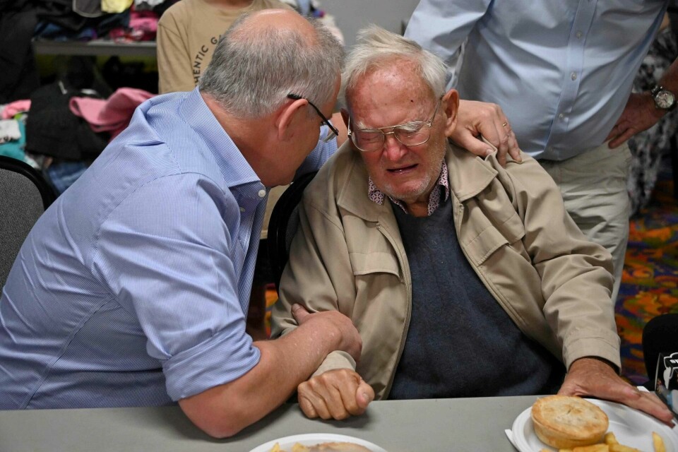 Australias statsminister Scott Morrison trøster 85 år gamle Owen Whalan, som måtte evakuere hjemmet sitt for noen dager siden. Foto: NTB scanpix Australias statsminister Scott Morrison trøster 85 år gamle Owen Whalan, som måtte evakuere hjemmet sitt for noen dager siden. Foto: NTB scanpix