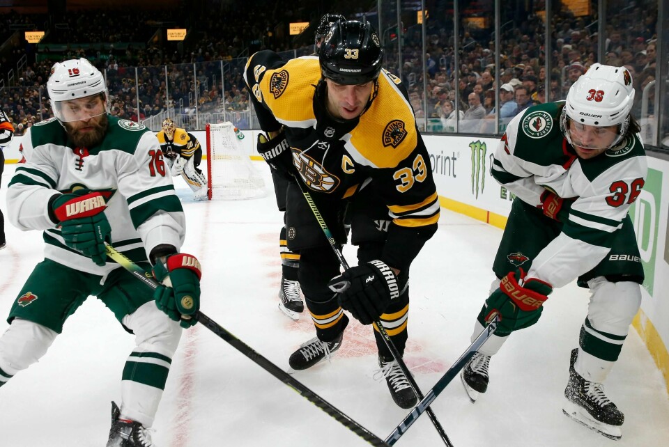 Boston Bruins' Zdeno Chara (33) i takling med Minnesota Wild's Jason Zucker (16) and Mats Zuccarello (36) under lørdagens kamp i NHL i Boston Foto: Michael Dwyer/ AP/ NTB scanpix