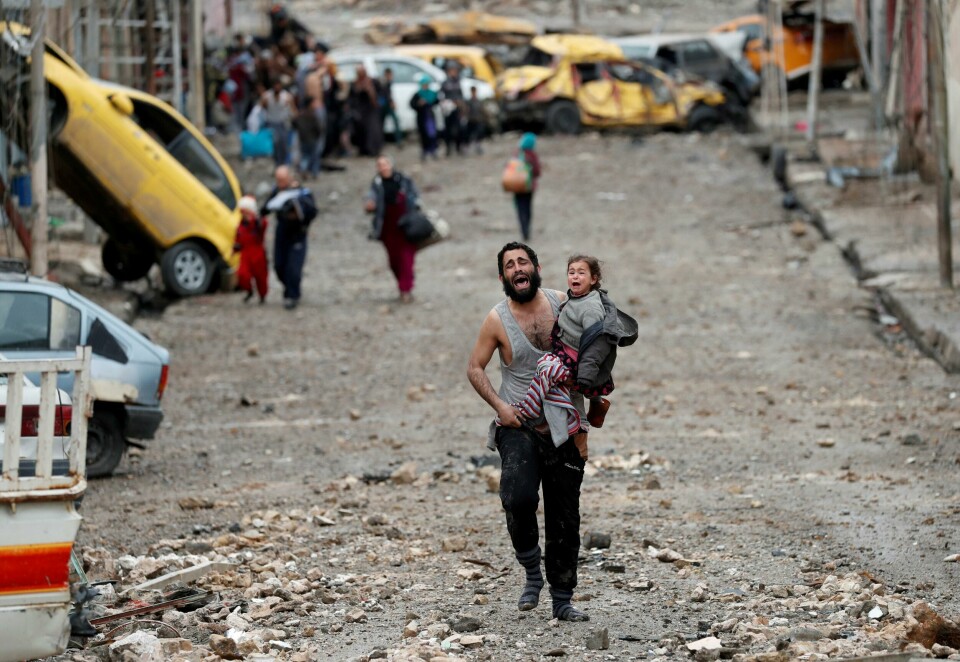 En mann gråter mens han bærer datteren sin fra en IS-kontrollert del av Mosul, Irak, mot irakiske spesialstyrker 4. mars 2017. Krigen mot IS er blant hendelsene som har preget det siste tiåret. A man cries as he carries his daughter while walking from an Islamic State controlled part of Mosul towards Iraqi special forces soldiers during a battle in Mosul, Iraq, March 4, 2017. Picture taken March 4, 2017. REUTERS/Goran Tomasevic/File Photo SEARCH 'POY DECADE' FOR THIS STORY. SEARCH 'REUTERS POY' FOR ALL BEST OF 2019 PACKAGES. TPX IMAGES OF THE DAY.