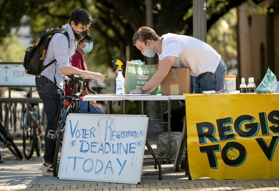 Deputy voter registrar Blake Zimmerman, right, helps professor Daniel Drucker register to vote at the University of Texas at Austin on Monday Oct. 5, 2020. Monday is the deadline to register to vote in Texas in the Nov. 3 local and national elections, including the races for president; congressional and legislative seats; governor; lieutenant governor; and city and county government and judicial posts. (Jay Janner/Austin American-Statesman via AP) Deputy voter registrar Blake Zimmerman, right, helps professor Daniel Drucker register to vote at the University of Texas at Austin on Monday Oct. 5, 2020. Monday is the deadline to register to vote in Texas in the Nov. 3 local and national elections, including the races for president; congressional and legislative seats; governor; lieutenant governor; and city and county government and judicial posts. (Jay Janner/Austin American-Statesman via AP)