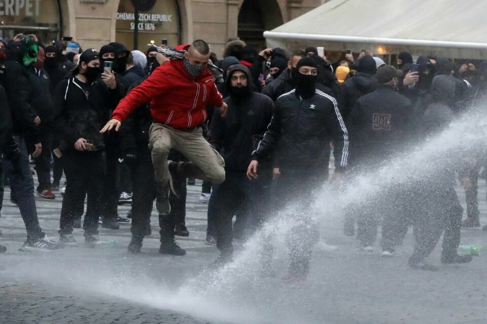 Politiet tok søndag i bruk vannkanoner for spre demonstranter i Praha. En folkemengde samlet seg for å demonstrere mot strenge koronatiltak som blant annet omfatter stans i idrettsarrangementer og stengning av barer og restauranter. Foto: Petr David Josek / AP / NTB