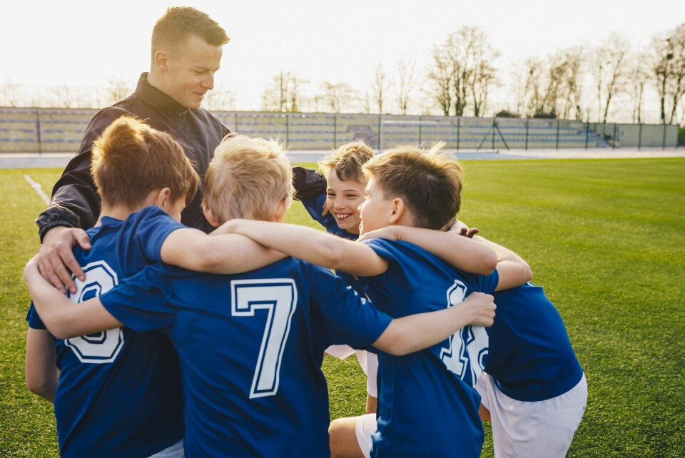 Group Of Children In Soccer Team Celebrating With Coach