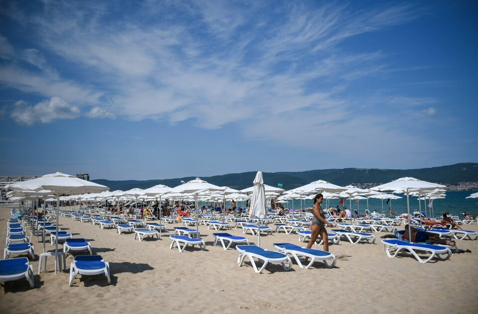 A photograph taken on July 16, 2020 shows a tourist walking near empty sunbeds and umbrellas at the beach in Sunny Beach, Bulgaria's biggest Black Sea resort. - Bulgaria is the poorest country in the EU and will be dealt a body blow by the virtual collapse of its tourism sector, which accounts for 12 percent of annual economic output. Initially Bulgaria managed to control its infection numbers but after easing its lockdown comparatively early, it has found itself in the midst of a fresh spike in infections. (Photo by NIKOLAY DOYCHINOV / AFP)