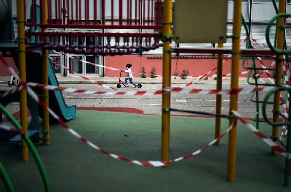 En jente på en sparkesykkel i Marseille i Frankrike. Lekeplassen i forgrunnen er stengt på grunn av koronaviruset. Bildet er tatt 14. mai. A girl rides a scooter past the Saint-Tronc Castelroc primary school playground, closed to prevent the spread of the coronavirus, in Marseille, France, on May 14, 2020. (AP Photo/Daniel Cole)