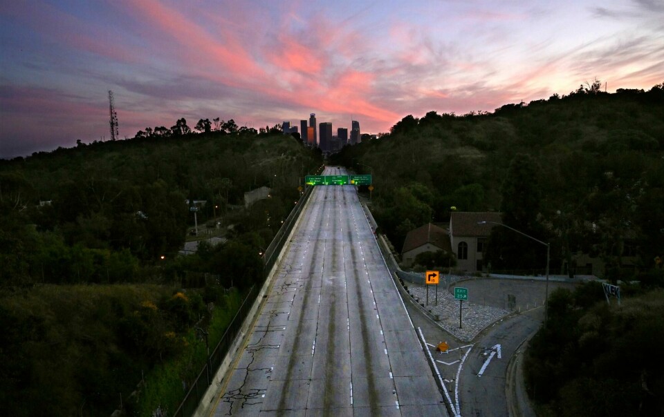 Ingen biler kjører på veiene utenfor Los Angeles 26. april. California er i lockdown. Empty lanes of the 110 Arroyo Seco Parkway lead to downtown Los Angeles on Sunday, April 26, 2020, during the coronavirus outbreak. (AP Photo/Mark J. Terrill, File)
