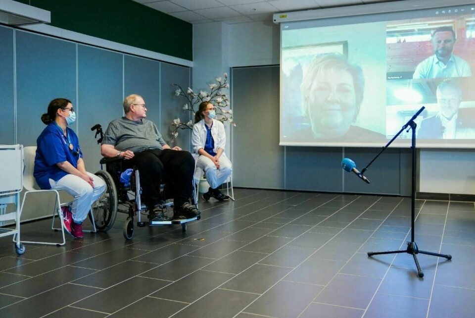 Bent Høie (øverst t.h.) følger den første koronavaksineringen i Norges historie via videolink.