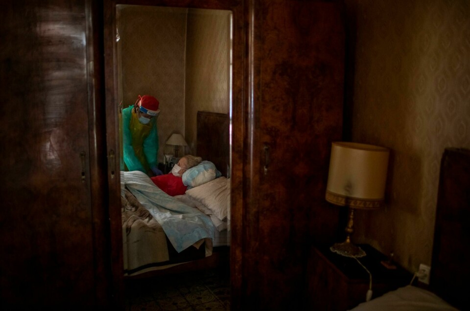 Josefa Ribas (86) som har demens og er sengeliggende, får hjelp av sykepleier Laura Valdes under et hjemmebesøk i Barcelona. Josefa Ribas, 86, who is bedridden and suffers from dementia, is attended to by nurse Laura Valdes during a home care visit in Barcelona, Spain, on April 7, 2020. Ribas' husband, Jose Marcos, fears what will happen if the coronavirus enters their home and infects them. 'I survived the post-war period (of mass hunger). I hope I survive this pandemic,' he said. (AP Photo/Emilio Morenatti)