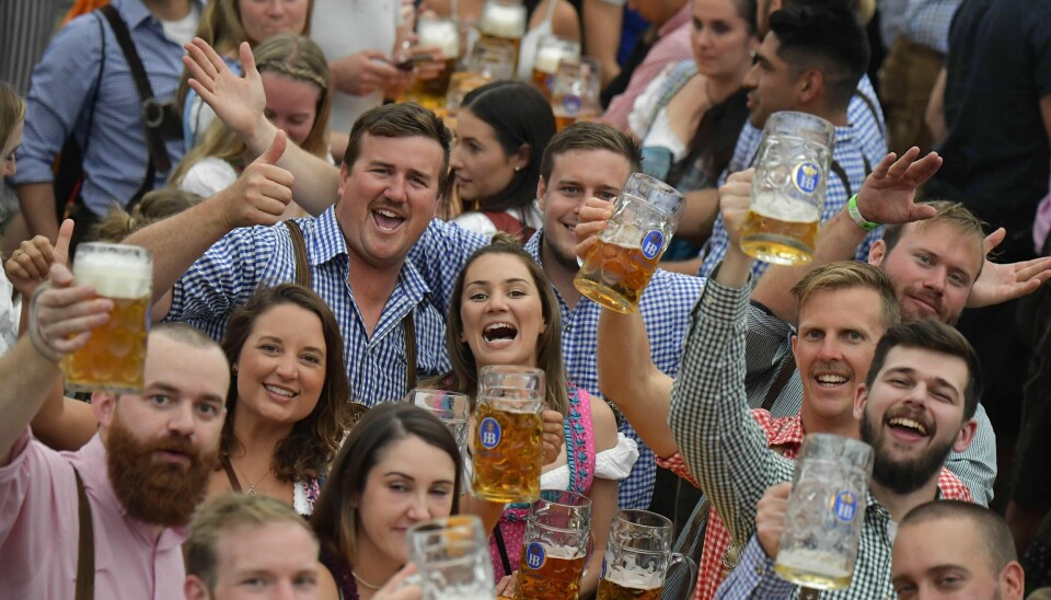 People in traditional Bavarian dress raise their beer glasses in a beer tent at the Oktoberfest beer festival in Munich, southern Germany, on September 22, 2019. - The world's biggest beer festival Oktoberfest will be running until October 6, 2019. (Photo by Tobias SCHWARZ / AFP)