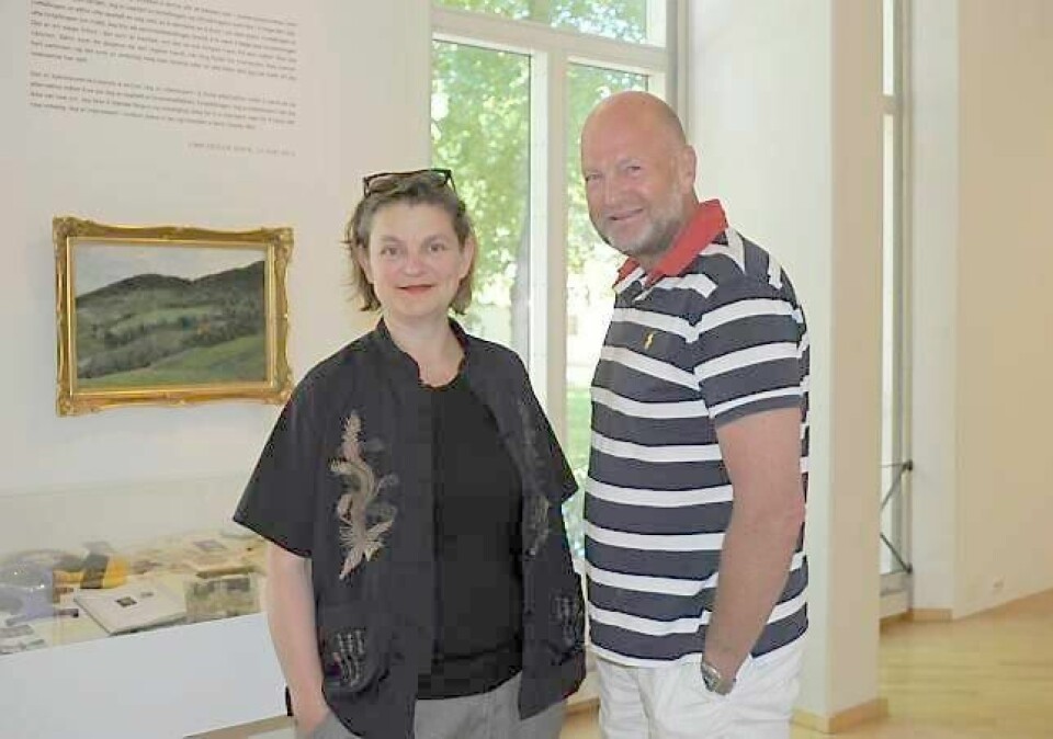 Linn Cecilie Ulvin, opprinnelig drammenser, viser blant annet et tablå av gjenstander etter sin mormor - under et bilde av Harriet Backer fra familiens arnested «Ulvin» på Morskogen. Leder i Drammen kunstforening Harald Gautneb er fascinert av kunstnerens mangslungne uttrykk. FOTO: PERNILLE VESTENGEN