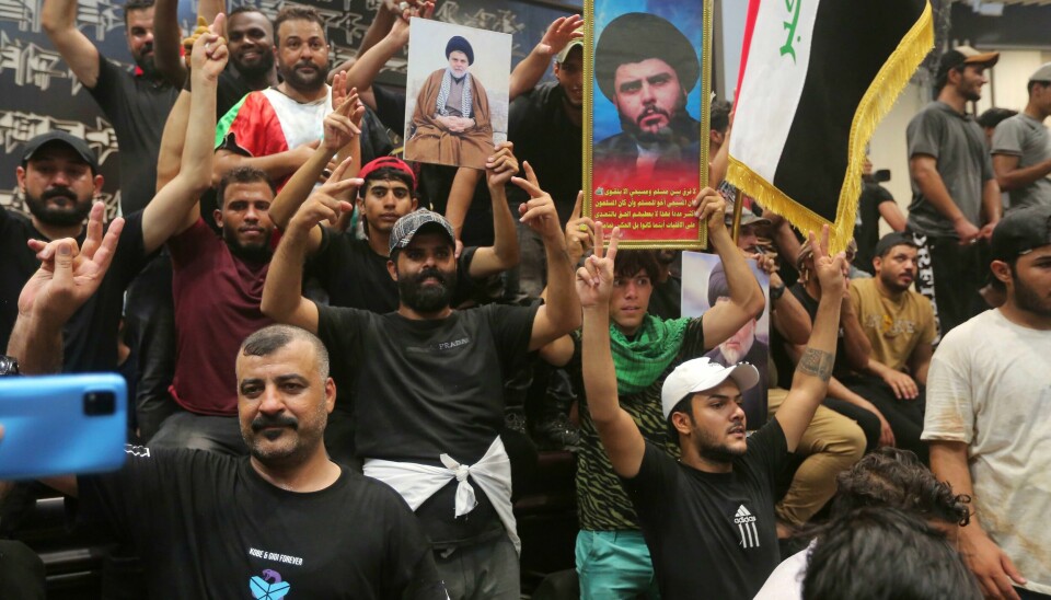 Demonstranter med flagg og bilder av Moqtada al-Sadr inne i nasjonalforsamlingen. Demonstranter med flagg og bilder av Moqtada al-Sadr inne i nasjonalforsamlingen. Foto: Anmar Khalil / AP / NTB
