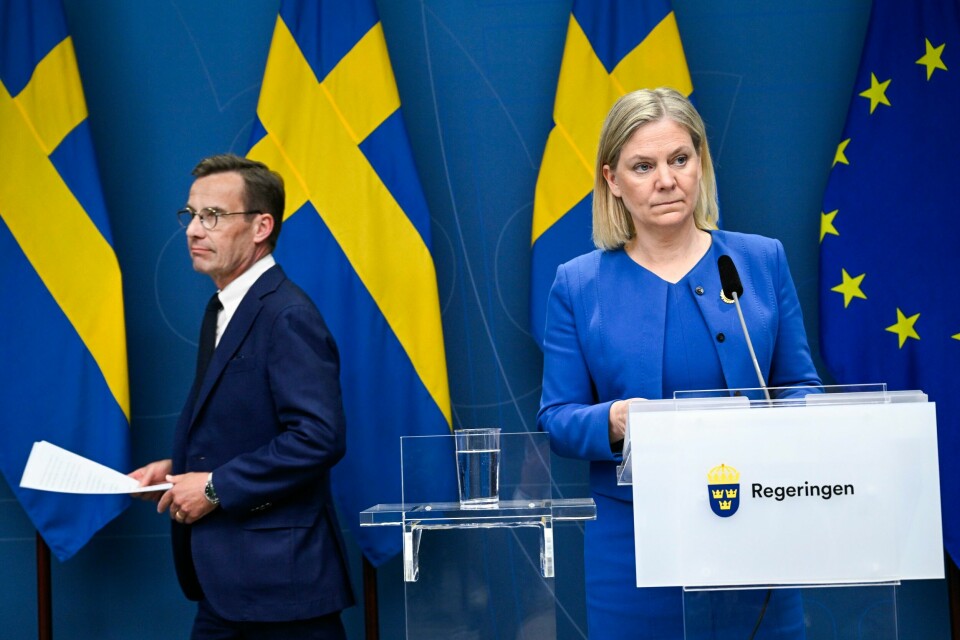 Moderaternas Ulf Kristersson og Socialdemokraternas Magdalena Andersson kjemper innbitt for å bli svensk statsminister ved riksdagsvalget søndag. Bildet er av Ulf Kristersson til venstre i bildet. Til høyre i bildet står statsminister Magdalena Andersson. De har en pressekonferanse. Det henger flere svenske flagg bak dem. Det henger også et EU-flagg. Foto: Henrik Montgomery / TT / AP / NTB