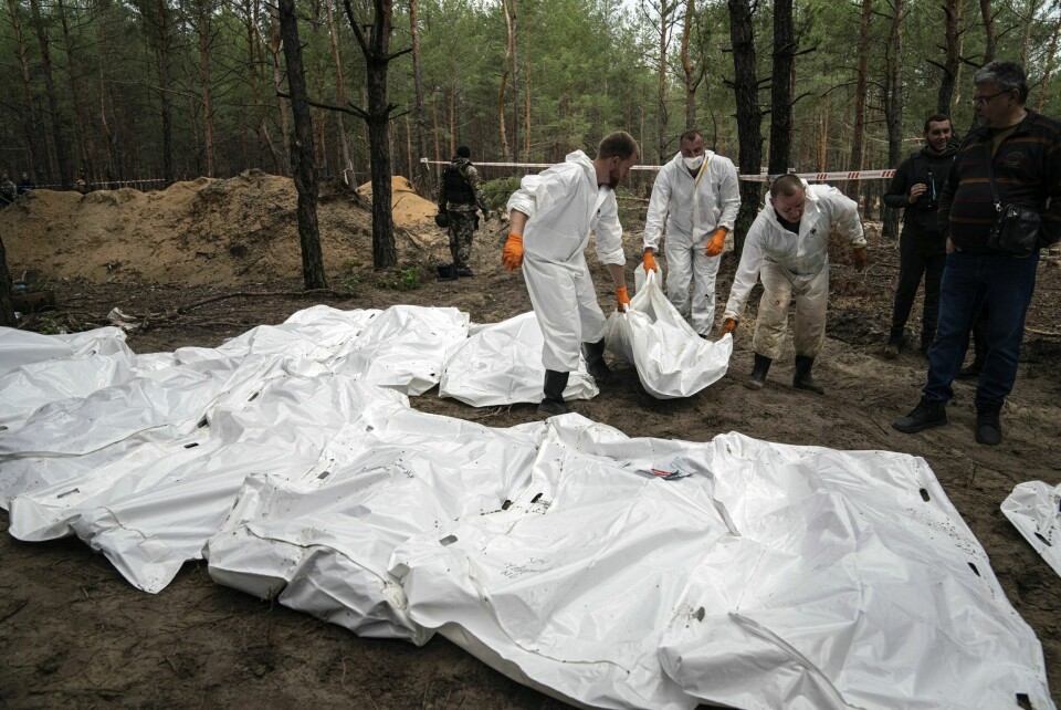 Ukrainsk personell henter opp levninger som er funnet i massegraven i Izium. Nå krever Tsjekkia at det opprettes en egen krigsforbryterdomstol for å straffeforfølge Russland. Personell jobber med å hente opp alle likene som ligger i massegravfeltet i Izium i Ukraina. Det er funnet over 440 graver i skogen utenfor byen. Foto: Jevhen Maloletka / AP / NTB