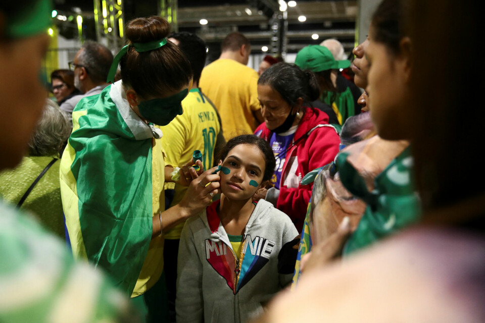 En kvinne får på seg ansiktsmaling for å delta på et valgmøte i regi av Brasils president Jair Bolsonaro. En kvinne får på seg ansiktsmaling for å delta på et valgmøte i regi av Brasils president Jair Bolsonaro.