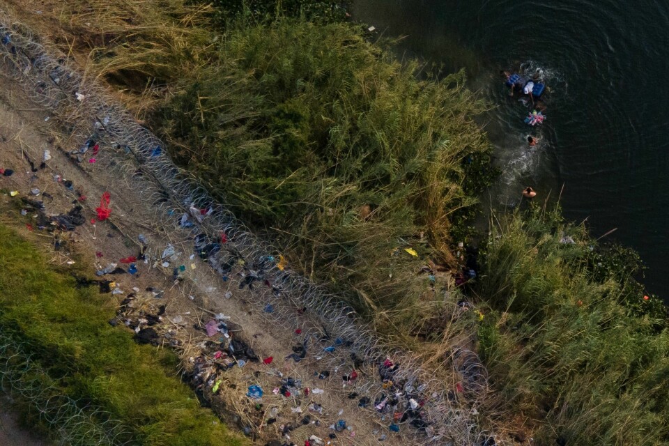 Migranter bruker en flåte for å krysse Rio Grande på grensen mellom Mexico og Texas i mai i år. Migranter bruker en flåte for å krysse Rio Grande på grensen mellom Mexico og Texas i mai i år.