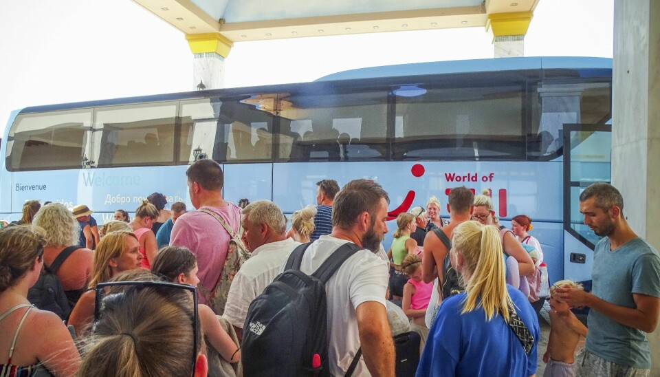 Turister venter på en buss som skal evakuere dem bort fra områder berørt av skogbrann på Rhodos. Det er uvisst om noen av de avbildede turistene er norske. Evakuerte turister venter på å komme seg om bord på busser ved et hotell på Rhodos. Foto: Argyris Mantikos / Eurokinissi / AP / NTB