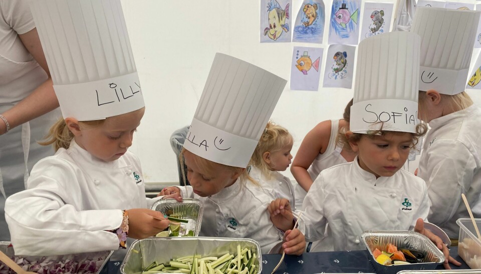 Lilly, Isabella og Sofia velger ut grønnsaker og sjømat til skattekistene sine. Tre jenter plukker ut mat.