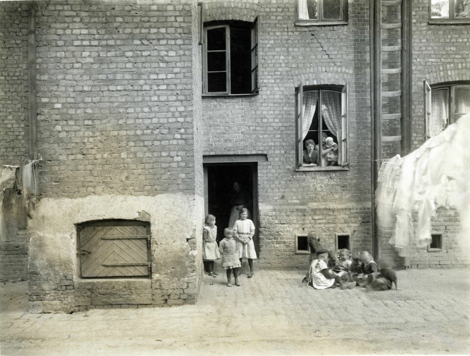 Barn i lek i bakgården til Gråbeinsgården i Kirkegårdsgata 22. Bakgård med barn i lek. Kirkegårdsgata. Klestørk. Barn i ring.