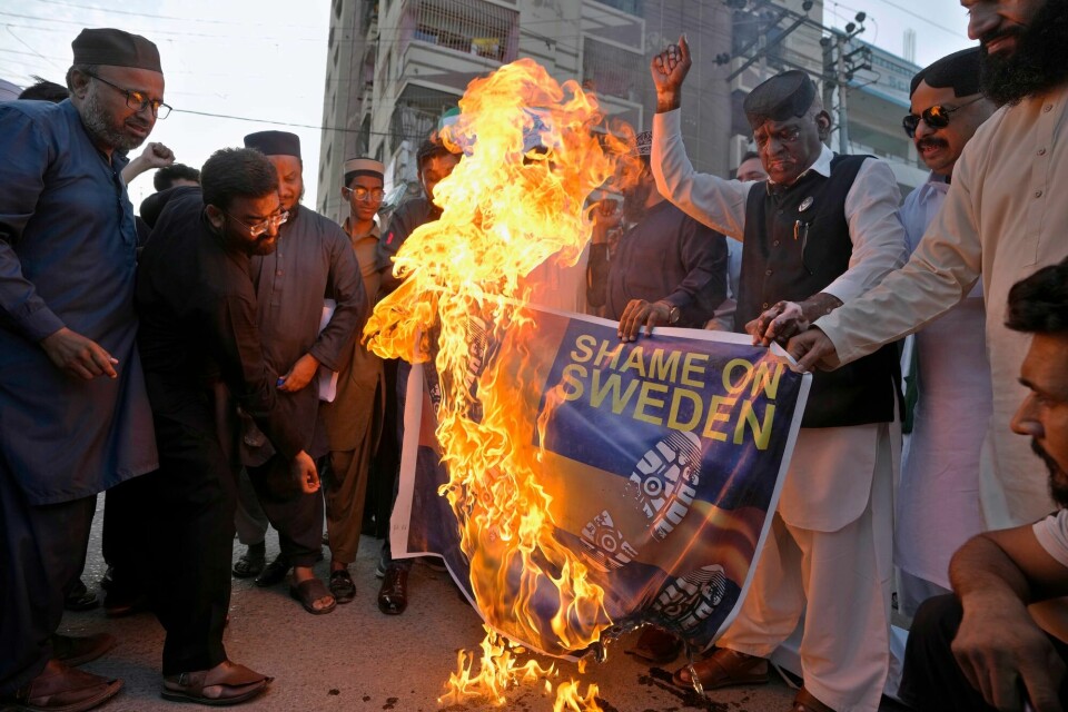 Demonstranter i brenner et plakat med det svenske flagget i Karachi i Pakistan i protest mot koranbrenningene i Sverige. Demonstranter i brenner et plakat med det svenske flagget i Karachi i Pakistan i protest mot koranbrenningene i Sverige.