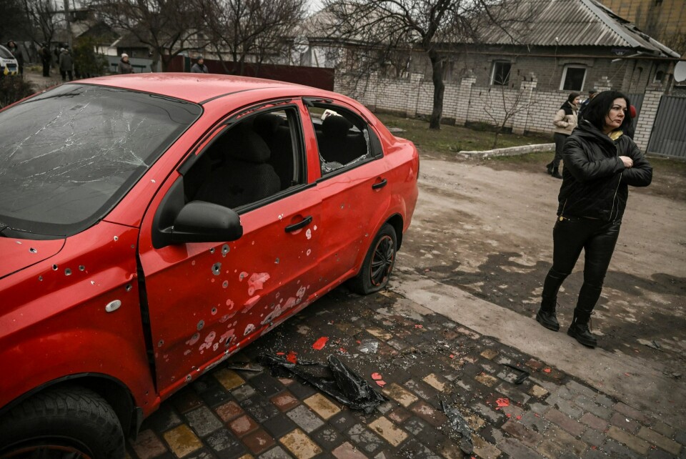 Klasevåpen har blitt brukt av både Russland og Ukraina under krigen. Våpentypen kritiseres blant annet fordi den ofte går utover sivile. Her fra et bombeangrep mot den ukrainske byen Kramatorsk den 18. mars 2023, som ligger omtrent 30 km unna Bakhmut. A woman stands next to a damaged car after a cluster bomb strike in Kramatorsk in the Donbas region on March 18, 2023. (Photo by Aris Messinis / AFP)