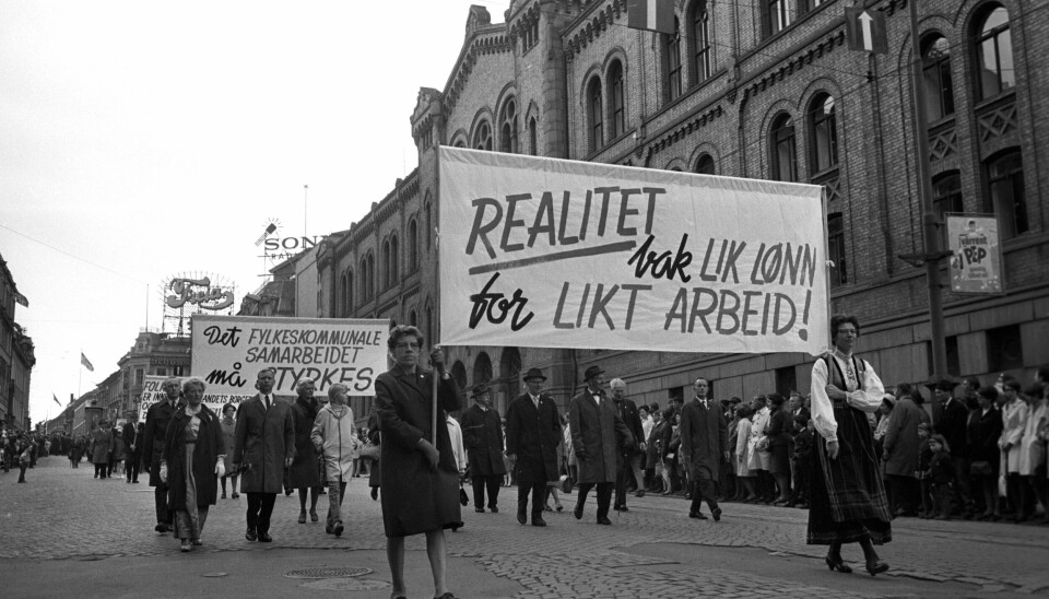 Likestilling i arbeidslivet har lenge vært en kampsak for mange. Dette er et bilde fra en demonstrasjon første mai i 1968. Første mai demonstrasjoner i Oslo i 1968. Her passerer første mai toget Stortinget på vei ned Karl Johans gate. Plakater med slagord om Lik lønn for likt arbeid.