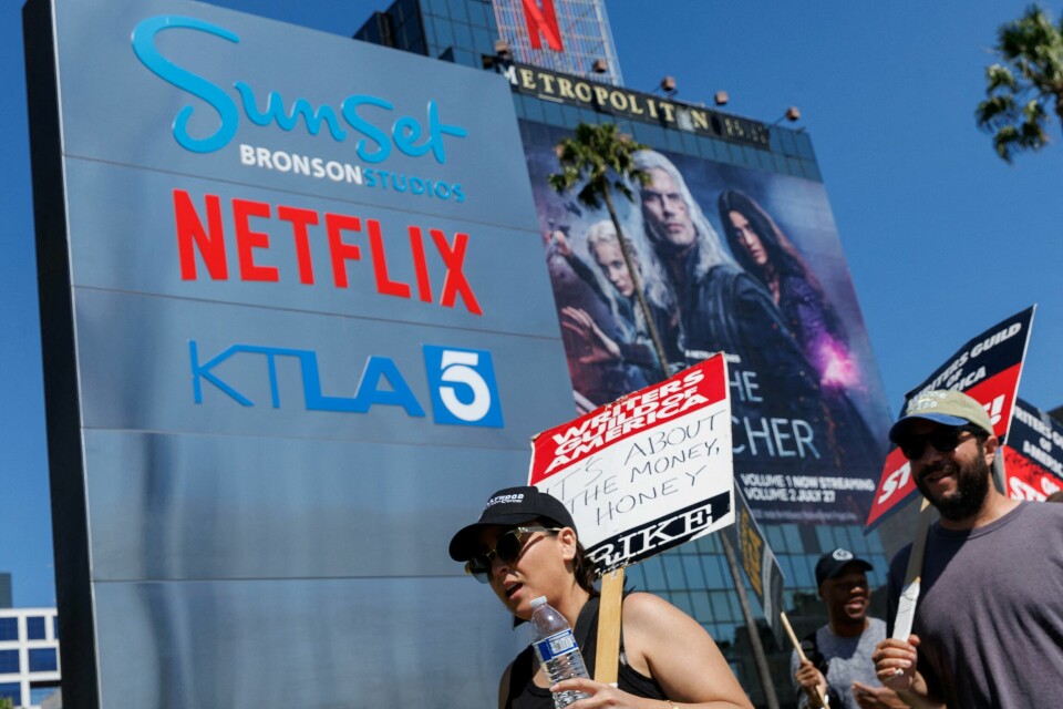 Den amerikanske manusforfatterforeningen, Writers Guild of America (WGA), deltar også i streiken. Her foran Netflix sitt kontor i Los Angeles 12 juli. På et av skiltene står det: 'It's about the money, honey'. Den amerikanske manusforfatterforeningen, Writers Guild of America (WGA), deltar også i streiken. Her foran Netflix sitt kontor i Los Angeles 12 juli. På et av skiltene står det: 'It's about the money, honey'.