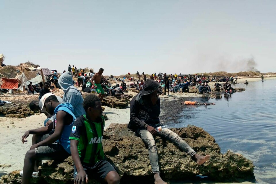 Dette bildet er tatt av en 29-åring fra Elfenbenskysten. Det skal vise en gruppe migranter, hvorav flere kvinner og små barn, etter at de ble fraktet bort og forlatt av myndighetene i Tunisia ved en øde strand nær grensen til Libya. Dette bildet er tatt av en 29-åring fra Elfenbenskysten. Det skal vise en gruppe migranter, hvorav flere kvinner og små barn, etter at de ble fraktet bort og forlatt av myndighetene i Tunisia ved en øde strand nær grensen til Libya. Foto: UGC via AP/NTB