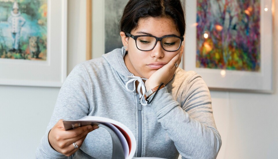 Hva om det er skolen selv som gjør barn syke, spør innleggsforfatteren. Illustrasjon av ungdom, jente som sitter og leser.
