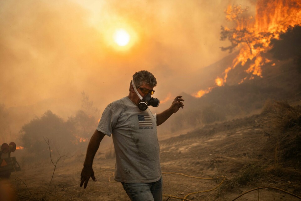 En mann bruker maske for å beskytte seg mot flammene ved landsbyen Gennadi på Rhodos. En mann bruker maske for å beskytte seg mot flammene ved landsbyen Gennadi på Rhodos.