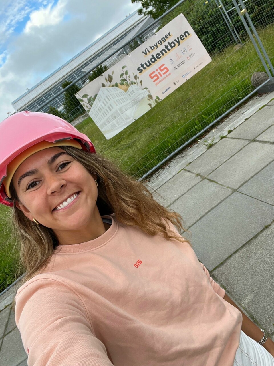Kristina Renberg er markeds- og kommunikasjonsdirektør i Studentsamskipnaden i Stavanger. En jente i SiS genser med en rosa hjelm på hodet. Hun smiler.