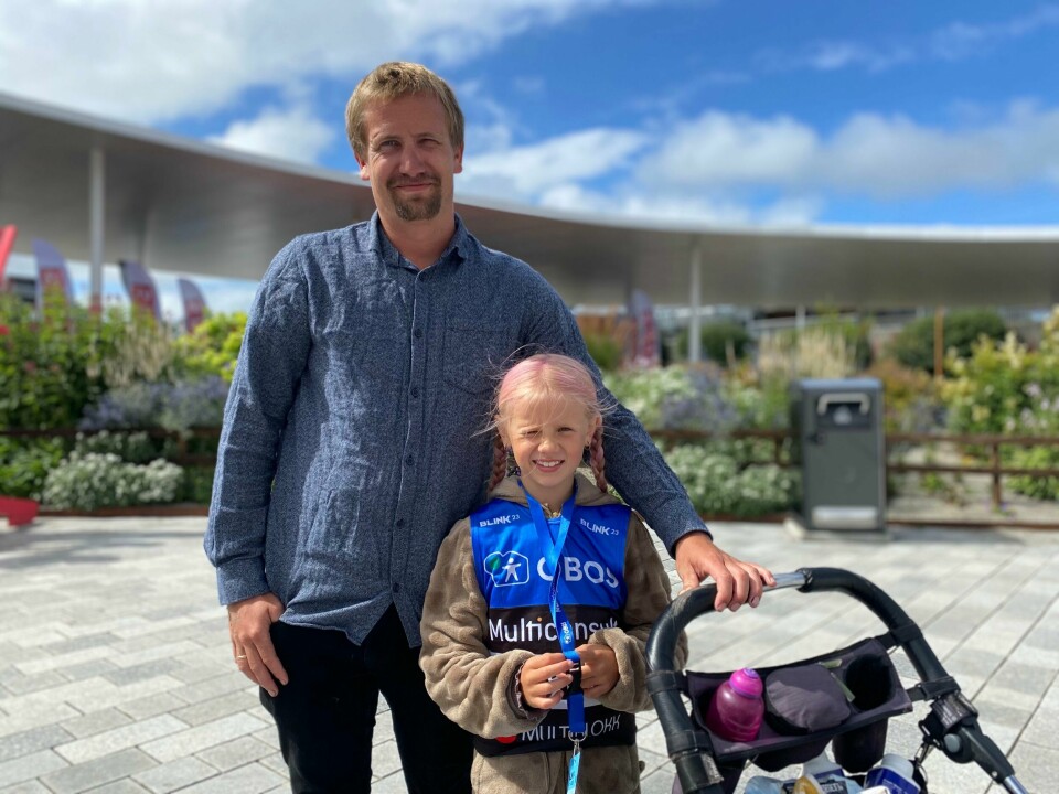 Kristian Vold og datteren Nora (8) har tatt toget til Sandes for å komme på Blinkfestivalen. En far og en datter med rosa hår står i Sandnes. Datteren har på OBOS t-skjorte.
