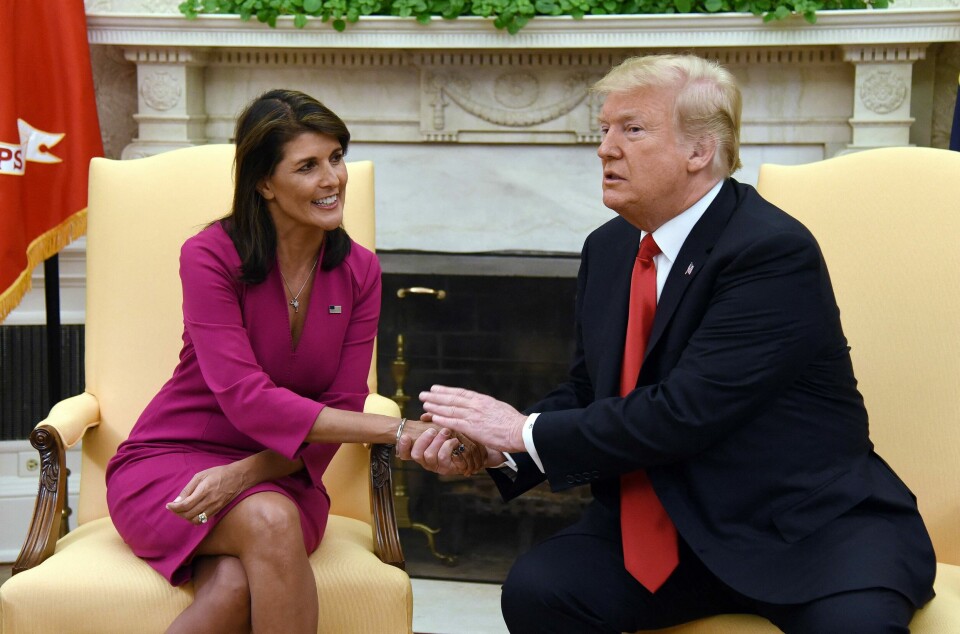 Nikki Haley og Donald Trump avbildet i Det ovale kontor i Det hvite hus i Washington D.C. Bildet ble tatt i oktober 2018, da Trump var president og Haley var USAs FN-ambassadør. (FILES) US President Donald Trump shakes hands with Nikki Haley, the United States Ambassador to the United Nations in the Oval office of the White House on October 9, 2018 in Washington, DC. Former presidential hopeful Nikki Haley said May 22, 2024 she will vote for Donald Trump in November's US election, ending months of silence after quitting the contest to choose a Republican to face Joe Biden. (Photo by Olivier Douliery / AFP)