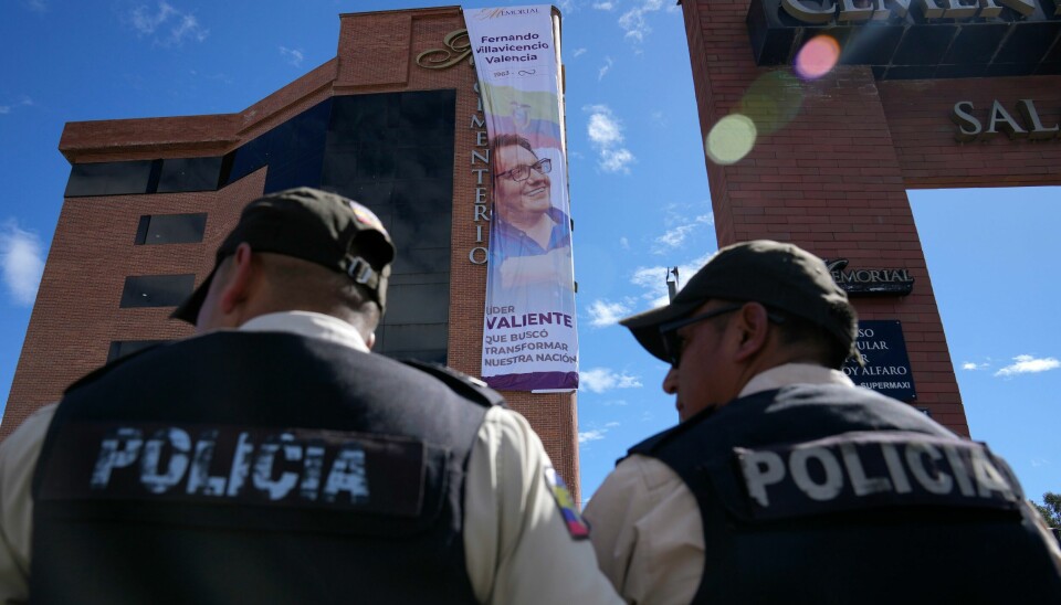To politibetjenter står vakt foran en plakat med et bilde av den drepte presidentkandidaten Fernando Villavicencio i Quito. To politibetjenter står vakt foran en plakat med et bilde av den drepte presidentkandidaten Fernando Villavicencio i Quito. Foto: Martin Mejia / AP / NTB