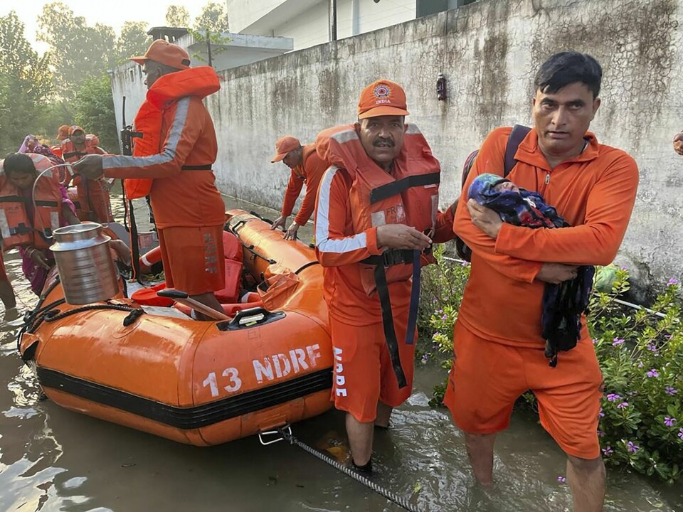 Redningsmannskaper hjelper et spedbarn i den flomrammede delstaten Himachal Pradesh. Flere dager med monsunregn i India har krevd over 70 menneskeliv. Redningsmannskaper hjelper et spedbarn i den flomrammede delstaten Himachal Pradesh. Flere dager med monsunregn i India har krevd over 70 menneskeliv. Foto: National Disaster Response Force via AP / NTB