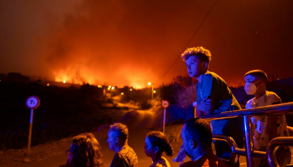 Lokalbefolkningen ser på mens flammene herjer i landsbyen Benijos på Tenerife. Lokalbefolkningen ser på mens flammene herjer i landsbyen Benijos på Tenerife. Foto: Arturo Rodriguez / AP / NTB