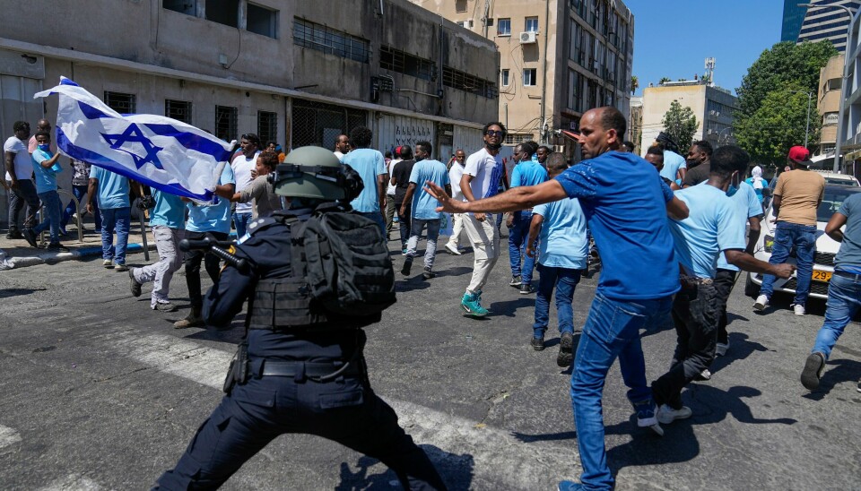 Eritreiske demonstranter i kamp med politiet i Tel Aviv. Titalls ble skadd i sammenstøt mellom politi og voldelgie demomstranter utenfor Eritreas ambassade i Israel lørdag. Foto: Ohad Zwigenberg / AP / NTB