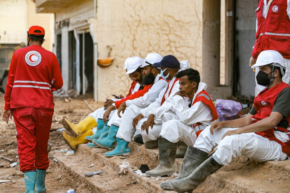 Flere hundre frivillige fra Røde Halvmåne har vært i sving siden forrige søndag. Rescue teams sit in Libya's eastern city of Derna on September 18, 2023, following deadly flash floods. A week after a tsunami-sized flash flood devastated the Libyan coastal city of Derna, sweeping thousands to their deaths, the international aid effort to help the grieving survivors slowly gathered pace. The enormous flood, fuelled by torrential rains on September 10, had broken through two upstream dams and sent a giant wave crashing down the previously dry river bed, or wadi, that bisects the city of about 100,000 people. (Photo by Mahmud Turkia / AFP)