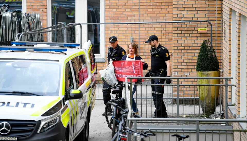 Leder Lene Haug fra aksjonsgruppa Redd Ullevål sykehus blir eskortert ut av politiet fra fløy E3 på Rikshospitalet 15. mai. Leder Lene Haug fra aksjonsgruppa Redd Ullevål sykehus blir eskortert ut av politiet fra fløy E3 på Rikshospitalet mandag morgen. Foto: Annika Byrde / NTB