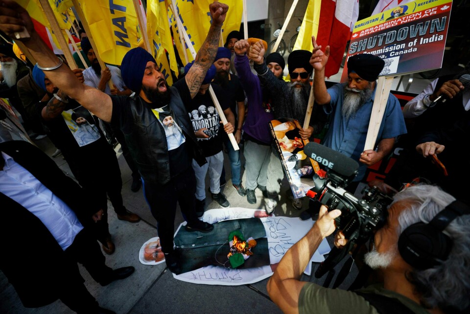 Demonstranter brenner et indisk flagg og tramper på en plakat av Indias statsminister Modi. Demonstranter brenner et indisk flagg og tramper på en plakat av Indias statsminister Modi.
