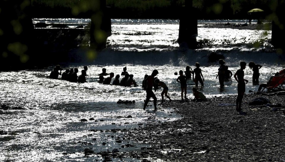 Folk bader og kjøler seg ned i elven Isar i München torsdag.