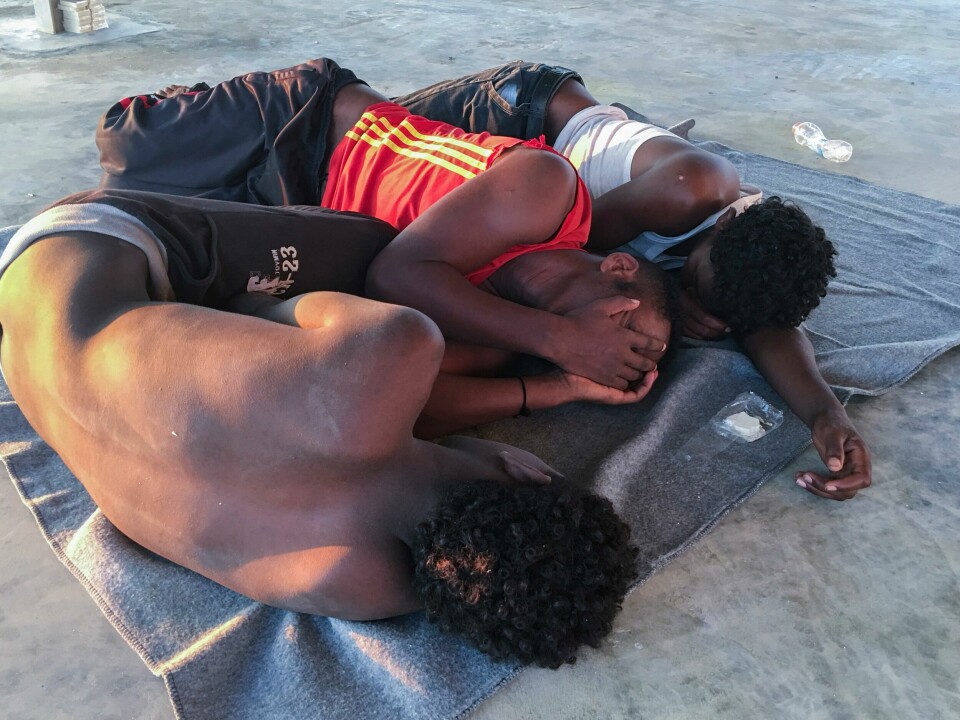 Overlevende hviler på et betonggulv på kysten av Libya fredag. Rescued migrants rest on a coast some 100 kilometers (60 miles) east of Tripoli, Libya, Thursday, July 25, 2019. The U.N. refugee agency and the International Rescue Committee say up to 150 may have perished at sea off the coast of Libya. The country's coast guard says the Europe-bound migrants are missing and feared drowned after the boats they were traveling on capsized in the Mediterranean Sea. A spokesman says they rescued around 137 migrants on Thursday. (AP Photo/Hazem Ahmed)