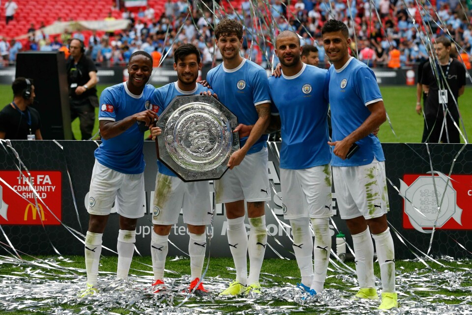 (L-R) Manchester City's English midfielder Raheem Sterling, Manchester City's Spanish midfielder David Silva, Manchester City's English defender John Stones, Manchester City's English defender Kyle Walker and Manchester City's Spanish midfielder Rodrigo pose with the trophy after winning the English FA Community Shield football match between Manchester City and Liverpool at Wembley Stadium in north London on August 4, 2019. (Photo by Ian KINGTON / AFP) / NOT FOR MARKETING OR ADVERTISING USE / RESTRICTED TO EDITORIAL USE (L-R) Manchester City's English midfielder Raheem Sterling, Manchester City's Spanish midfielder David Silva, Manchester City's English defender John Stones, Manchester City's English defender Kyle Walker and Manchester City's Spanish midfielder Rodrigo pose with the trophy after winning the English FA Community Shield football match between Manchester City and Liverpool at Wembley Stadium in north London on August 4, 2019. (Photo by Ian KINGTON / AFP) / NOT FOR MARKETING OR ADVERTISING USE / RESTRICTED TO EDITORIAL USE