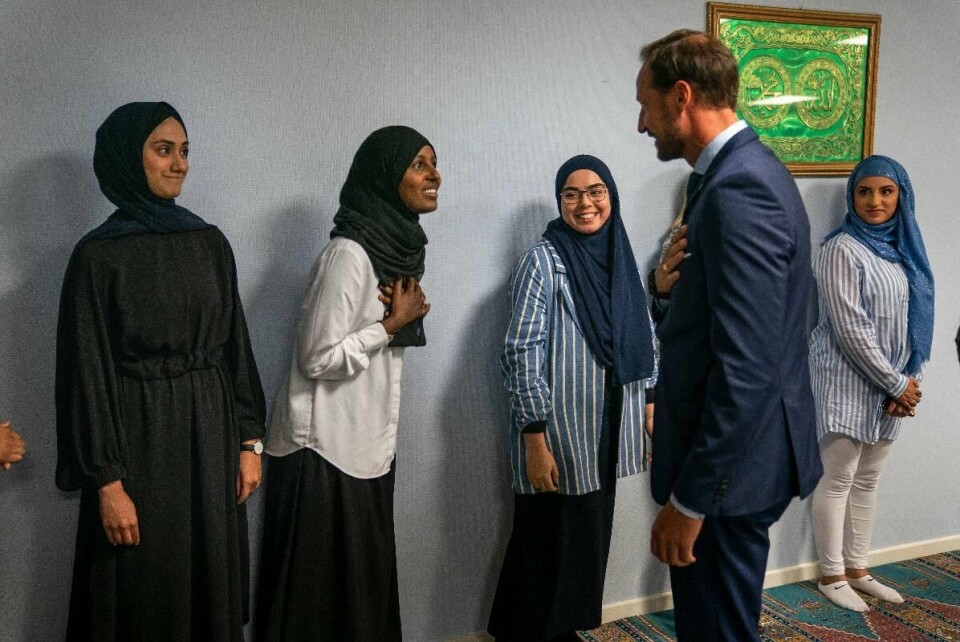 Kronprinsen hilser på Fatima (t.v.), Faiza og Sriha i ett av rommene som nå benyttes som bønnerom, i påvente av at hovedrommet skal bli klart igjen.