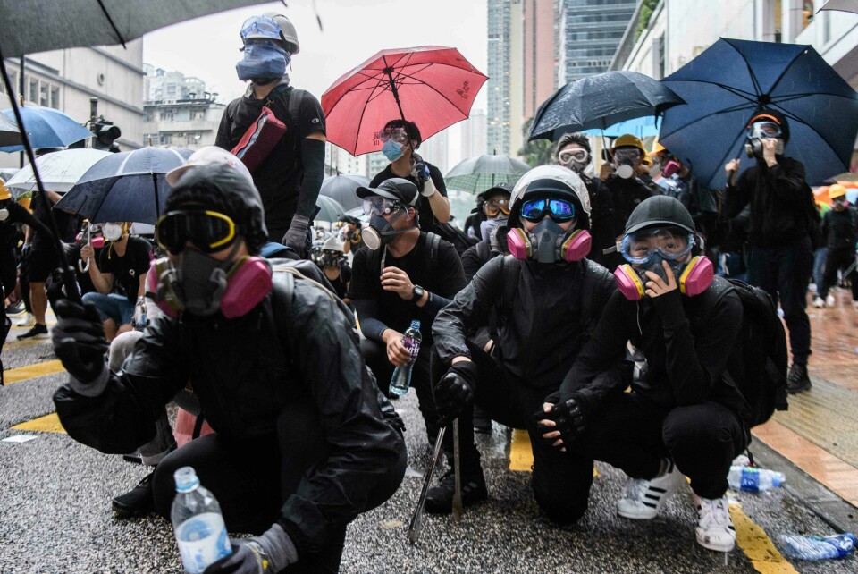 TOPSHOT - In this picture taken on August 25, 2019, Abby (front R), 19, and her boyfriend Nick, 20, (front 2nd R) crouch down while holding hands as they wait for police to fire tear gas during a protest in Tsuen Wan, an area in the New Territories in Hong Kong. - A gas mask lovingly adjusted, a hand squeezed before approaching police lines?and a frantic search through swirls of tear gas -- Abby and Nick's relationship has blossomed on the barricades during Hong Kong's long summer of protest.? (Photo by Anthony WALLACE / AFP) / TO GO WITH AFP STORY HONG KONG-POLITICS-CHINA-UNREST-PROTEST,FOCUS BY AIDAN JONES AND JASMINE LEUNG TOPSHOT - In this picture taken on August 25, 2019, Abby (front R), 19, and her boyfriend Nick, 20, (front 2nd R) crouch down while holding hands as they wait for police to fire tear gas during a protest in Tsuen Wan, an area in the New Territories in Hong Kong. - A gas mask lovingly adjusted, a hand squeezed before approaching police lines?and a frantic search through swirls of tear gas -- Abby and Nick's relationship has blossomed on the barricades during Hong Kong's long summer of protest.? (Photo by Anthony WALLACE / AFP) / TO GO WITH AFP STORY HONG KONG-POLITICS-CHINA-UNREST-PROTEST,FOCUS BY AIDAN JONES AND JASMINE LEUNG
