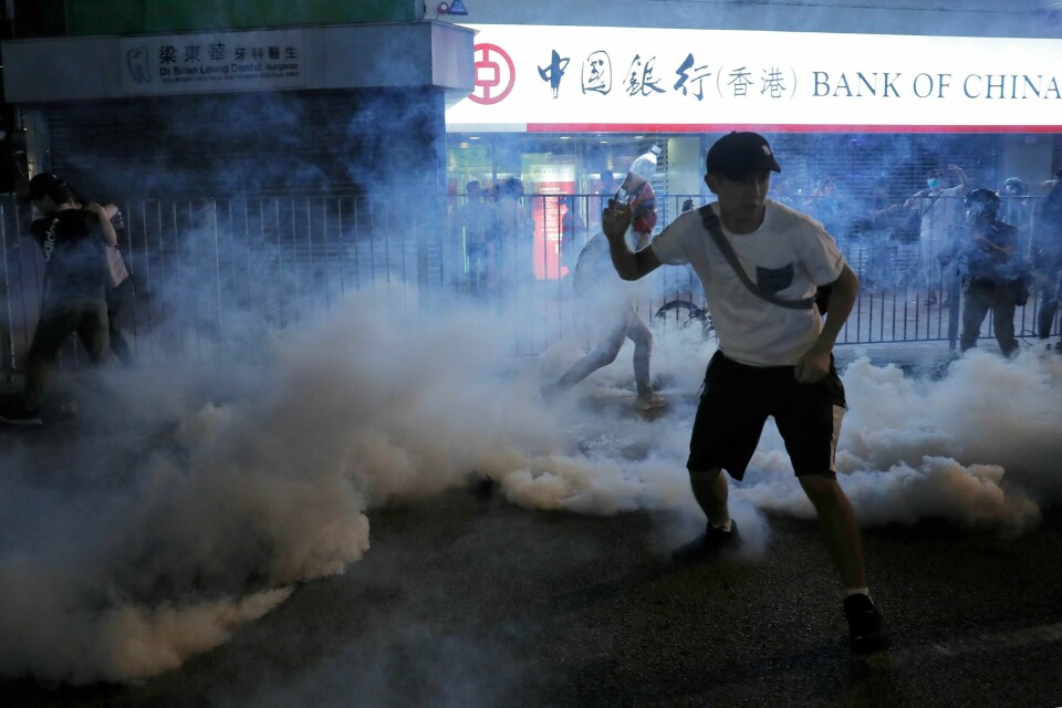 Politiet brukte gummikuler og tåregass mot demonstranter som kastet brannbomber i sentrum av Hongkong natt til søndag. Foto: AP / NTB scanpix