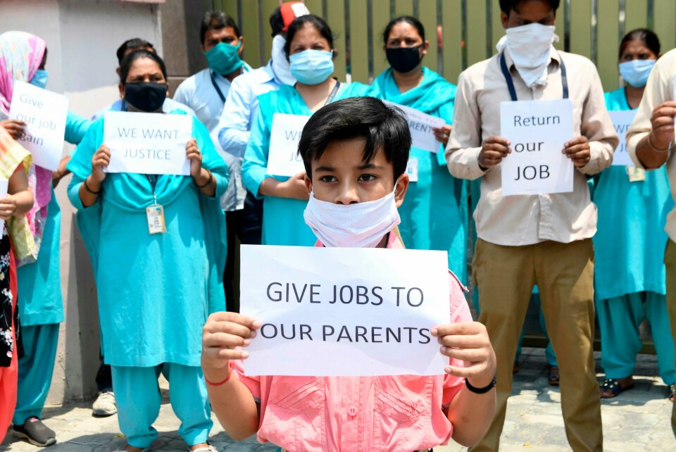 Over hele verden har mange mistet jobbene sine over natten på grunn av koronaen. I Amritsar i India demonstrerte lærere og barna deres i begynnelsen av juni, med krav om at oppsigelser ble omgjort. Employees who were sacked by DAV Public school hold placards demanding their jobs back after the government eased a nationwide lockdown imposed as a preventive measure against the COVID-19 coronavirus, in Amritsar on June 5, 2020. (Photo by NARINDER NANU / AFP)