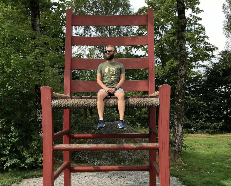 Vår kommentator dingler med beina fra verdens største jærstol på Sande i Hjelmeland, et av hans anbefalte turistmål for årets norgesferie.Foto: Privat