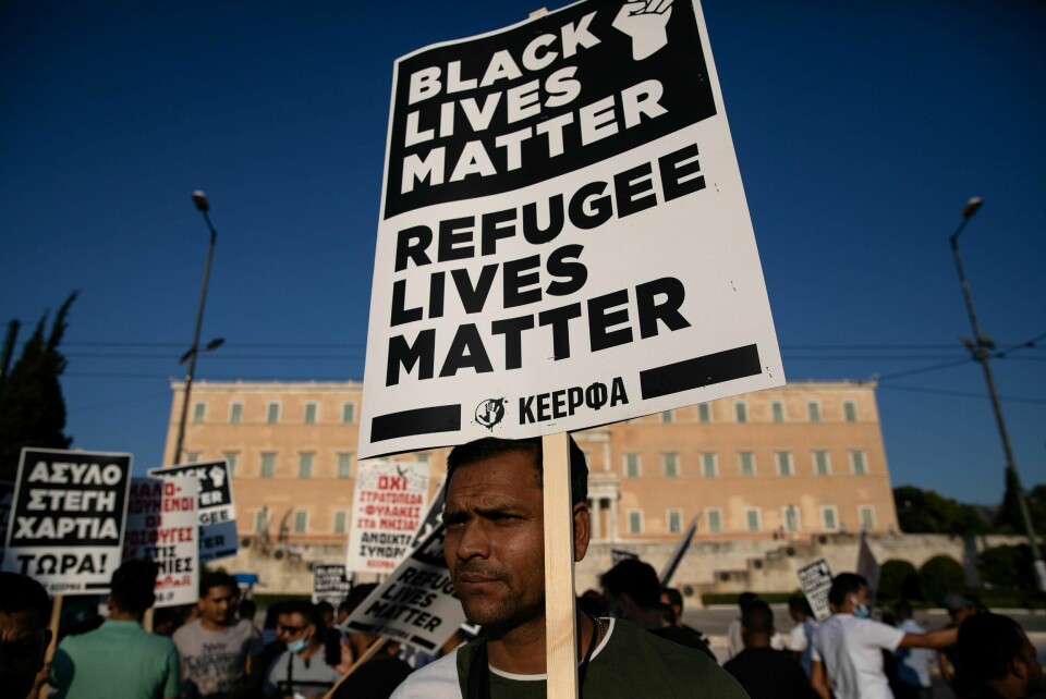 En migrant deltar på en demonstrasjon mot loven som betyr at opptil flere tusen flyktninger og migranter må forlate leilighetene de har fått bo i.